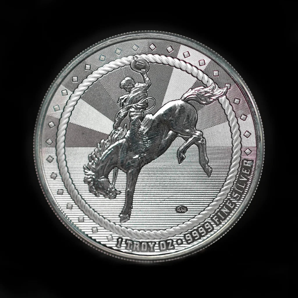 A 1 oz silver round with an image of a cowboy riding a bucking bronco on one side and a Buffalo privy mark on the other, struck by Scottsdale Mint.