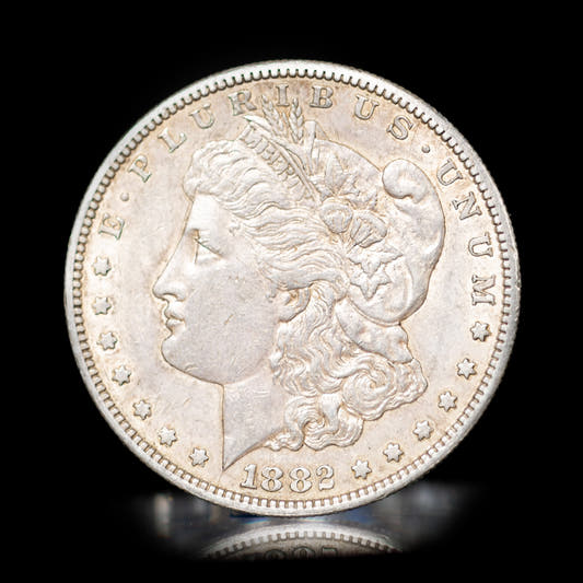 A collectible Morgan silver dollar coin with the portrait of a woman on the obverse and a eagle on the reverse, against a black background.