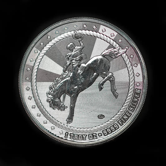 A 1 oz silver round with an image of a cowboy riding a bucking bronco on one side and a Buffalo privy mark on the other, struck by Scottsdale Mint.