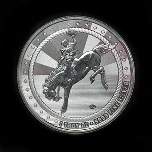 A 1 oz silver round with an image of a cowboy riding a bucking bronco on one side and a Buffalo privy mark on the other, struck by Scottsdale Mint.